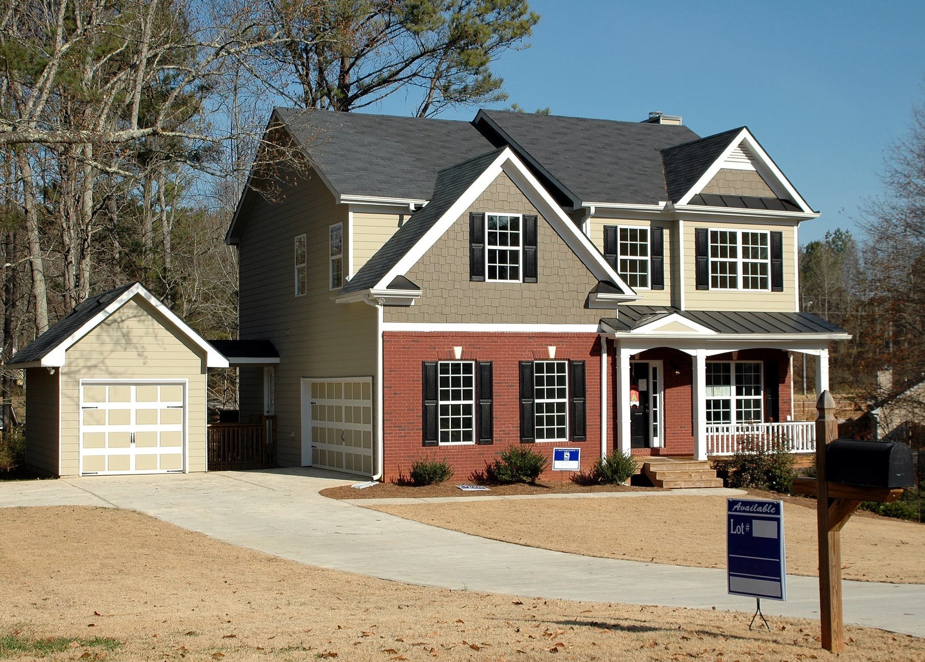White, grey and red house with driveway and external garage