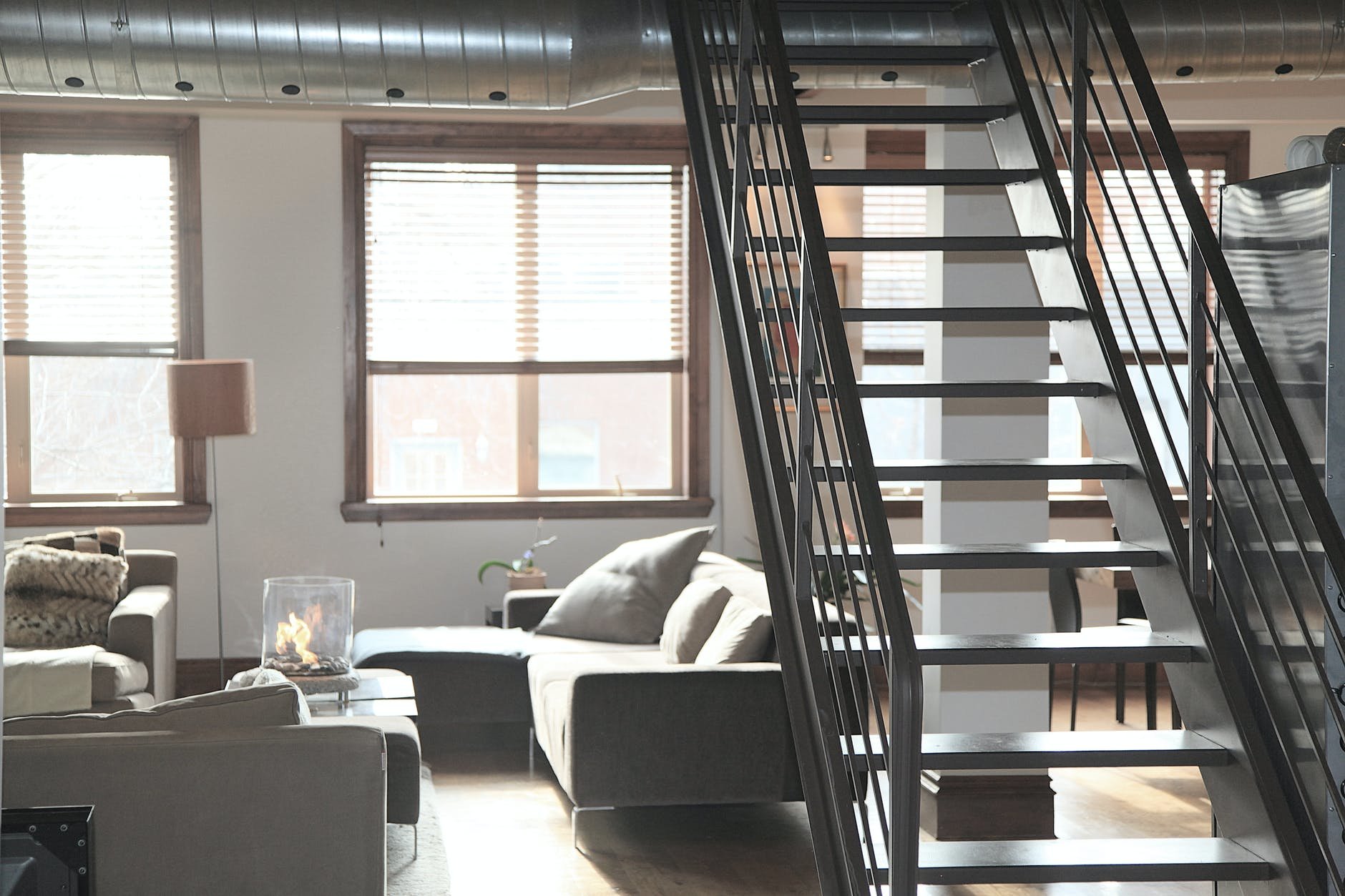 house interior with grey couch next to sunlit windows